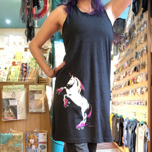 Person wearing a black sleeveless dress with a roller skating unicorn design in a store.