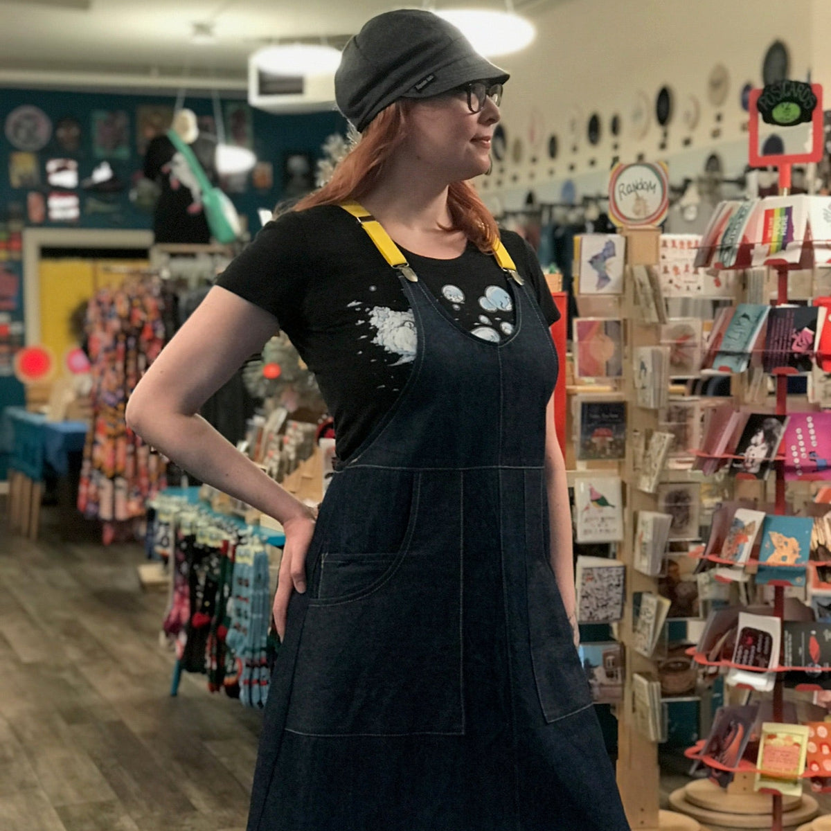 Person wearing a dark blue apron dress in a store setting. 