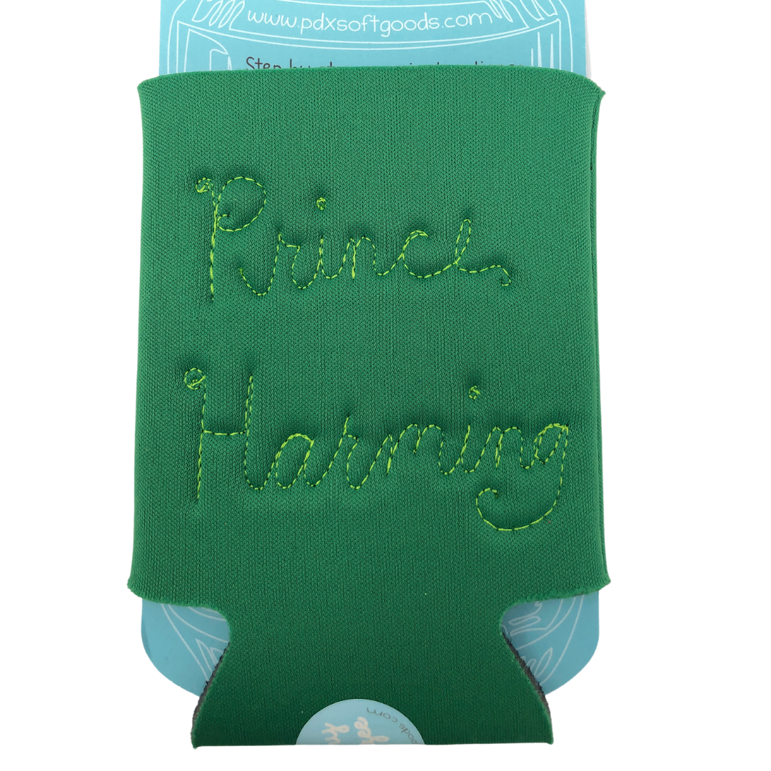 Green neoprene drink holder with "Prince Harming" embroidered on the back in cursive. 