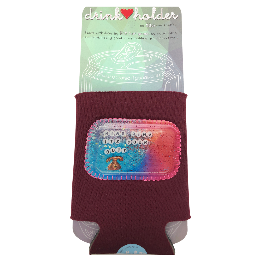 Maroon neoprene drink holder with a patch on the front that says, "Ring Ring It's your butt." 