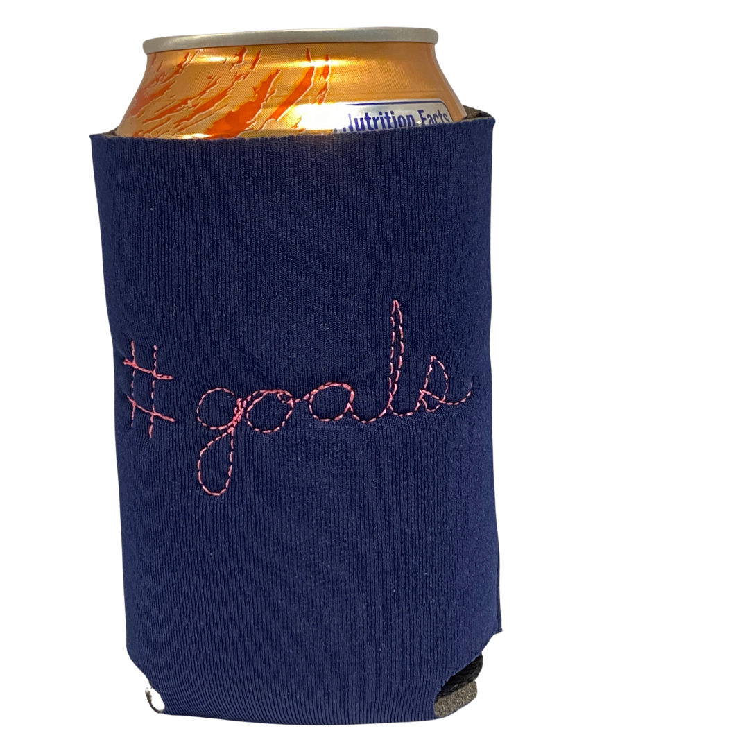 Purple neorene drink holder with "#goals" embroidered on the back in cursive. 