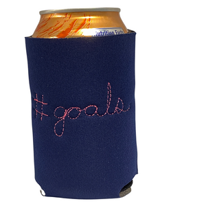 Purple neorene drink holder with "#goals" embroidered on the back in cursive. 