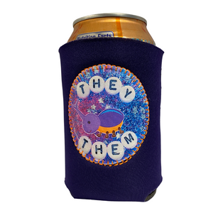 A purple drink holder with a patch on the front that says "They/Them" 
