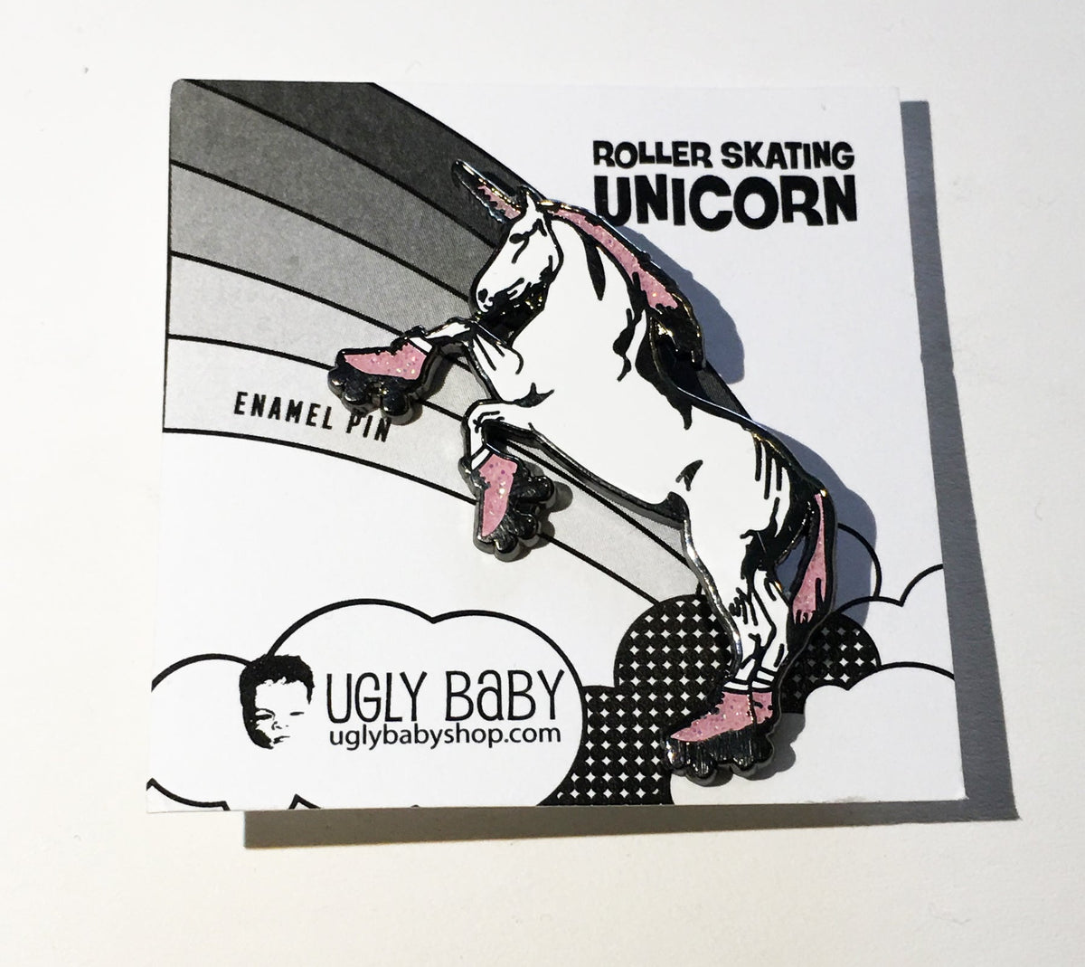An enamel pin of a unicorn standing on hind legs and wearing roller skates. 