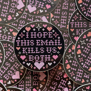 A circular cross-stitch style sticker with a black background and pink and white stitched text reading 'I HOPE THIS EMAIL KILLS US BOTH,' surrounded by repeated matching circular designs in the background.