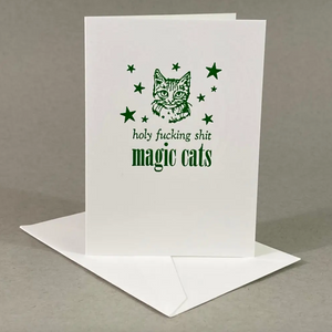 Letterpressed greeting card with a cat illustration and text that says "Holy fucking shit magic cats" on a white background. 