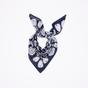 Blue and white floral-patterned bandana tied into a scarf. 