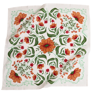 White bandana with a orange and green floral pattern. 