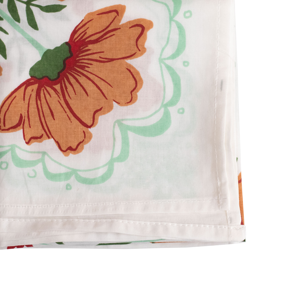 Detail of the corner of a white bandana with an orange and green floral pattern. 