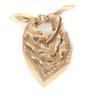 A cream colored bandana with a grid pattern tied into a scarf