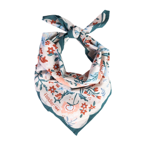 A floral patterned bandana folded and tied into a neck scarf.