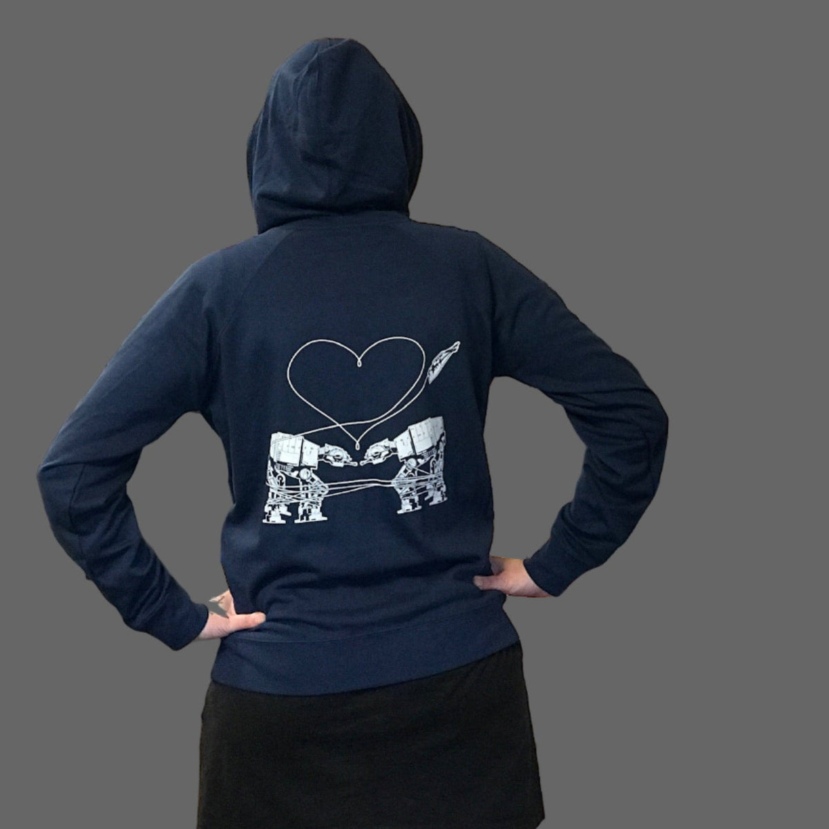 Person wearing a navy hoodie with the Love AT-AT First Sight design. 