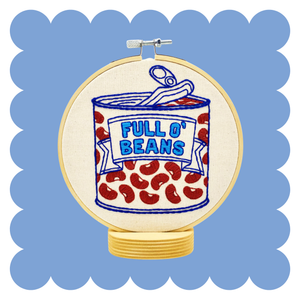 Decorative hoop with a can of beans embroidery illustration on a blue background