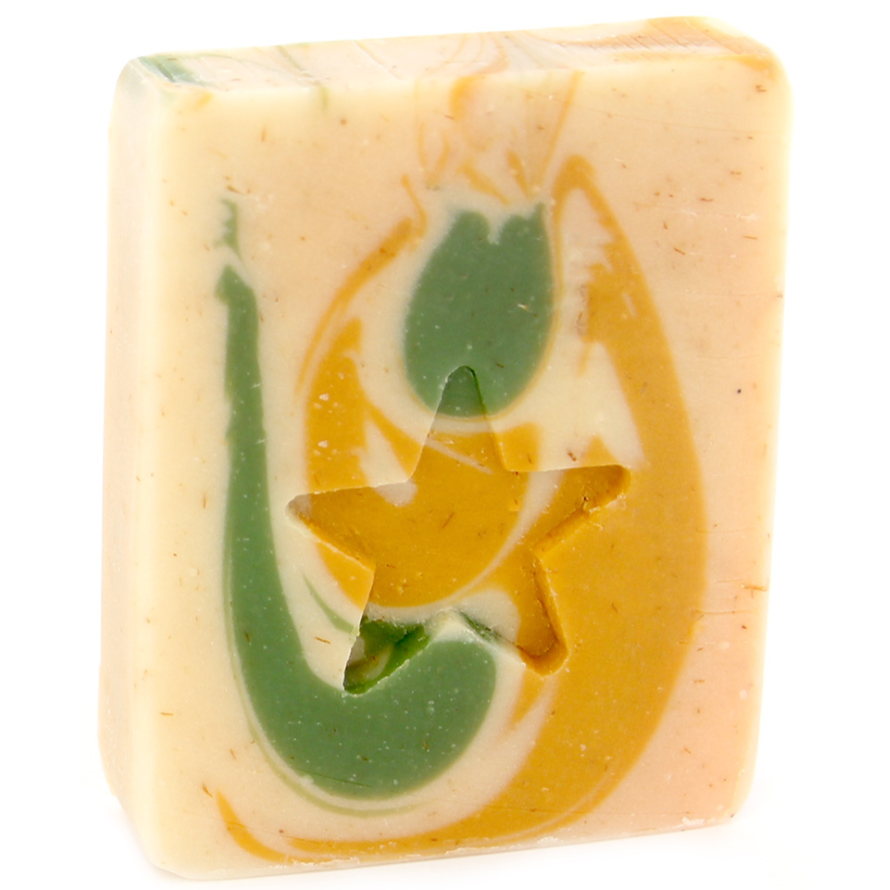 A bar of handmade soap with natural colors and patterns, predominantly beige with green and yellow swirls.