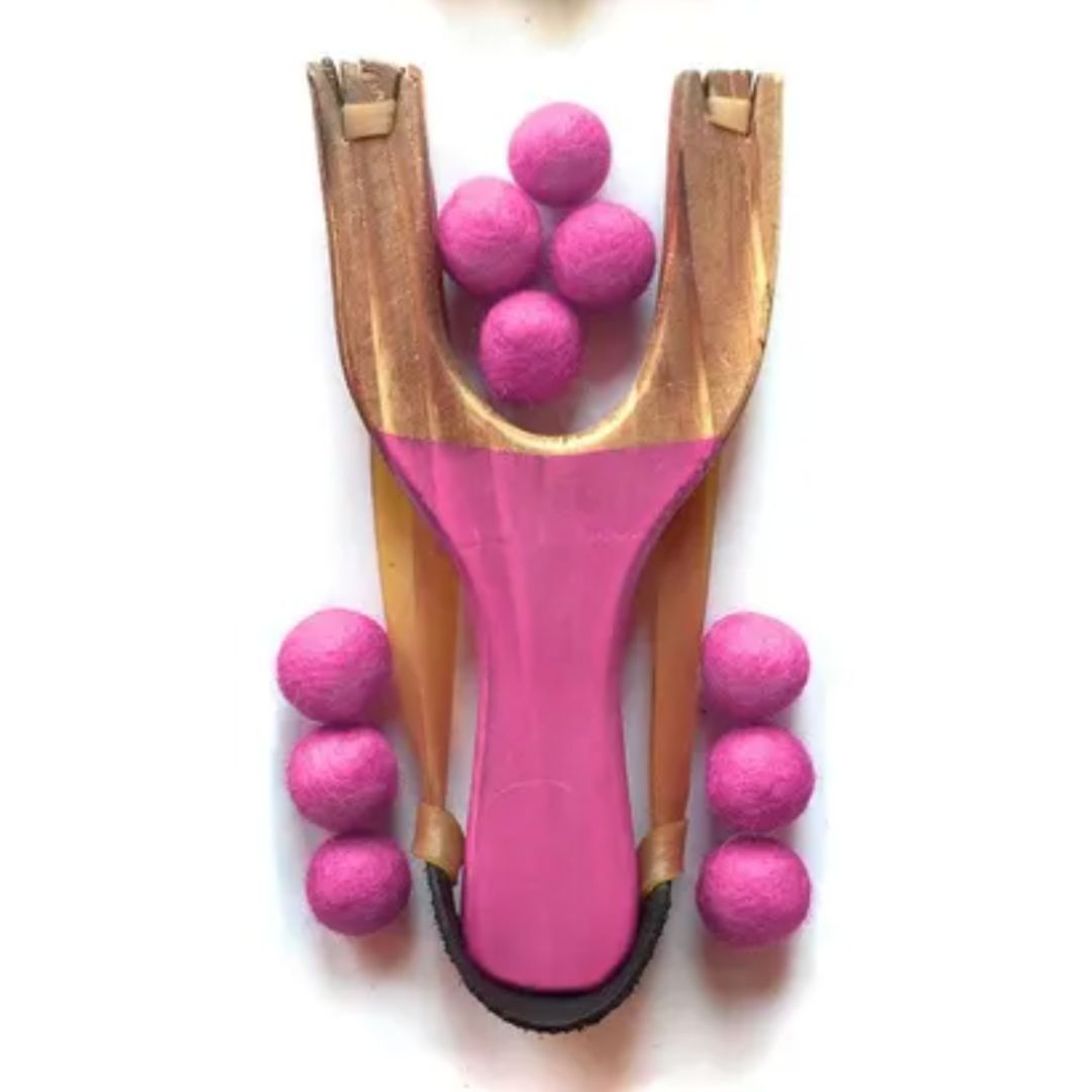 Pink slingshot with pink balls on a white background