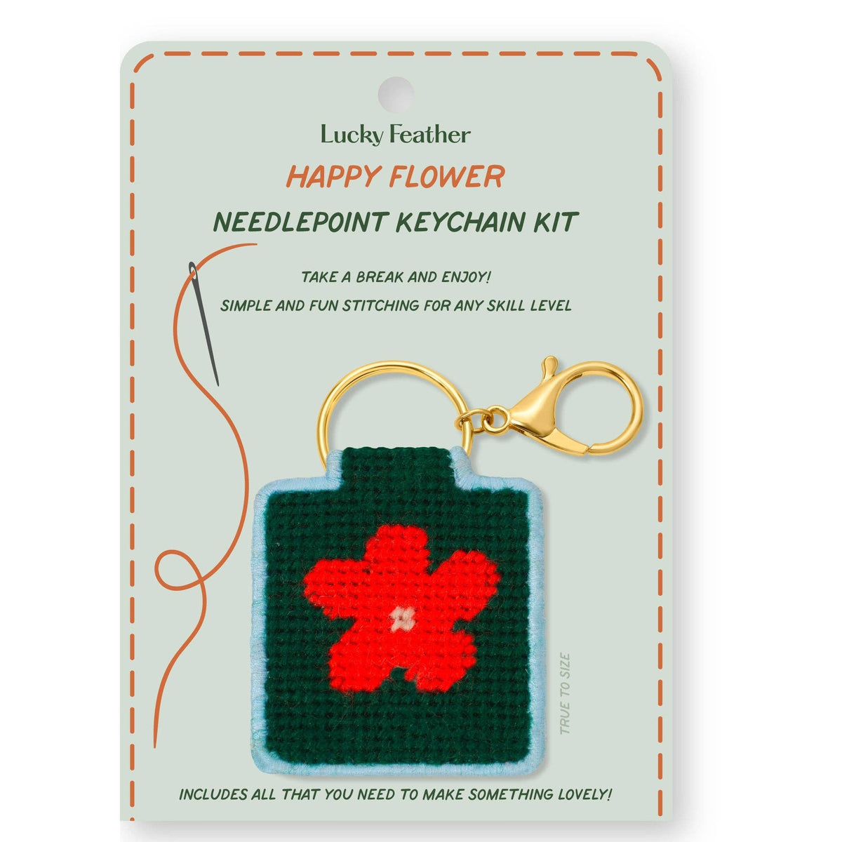 Craft kit for a needlepoint keychain that has a red flower on a green background with a blue border. 
