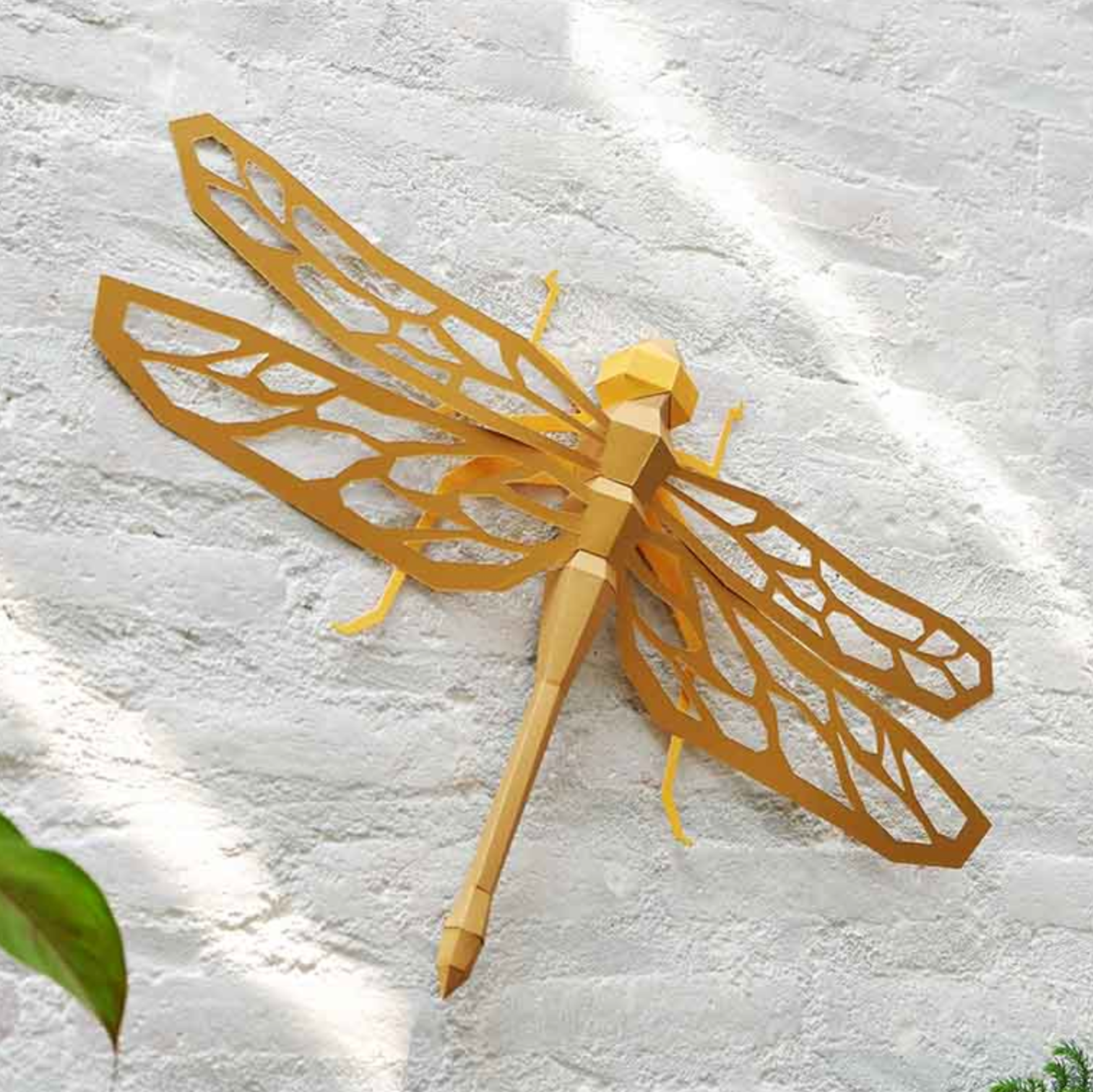 Gold dragonfly wall art on a textured white wall