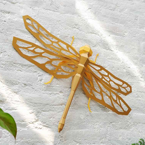 Gold dragonfly wall art on a textured white wall