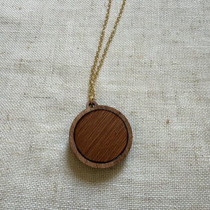 Wooden pendant necklace on a light fabric background