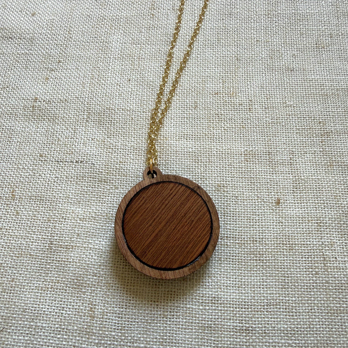 Wooden pendant necklace on a light fabric background
