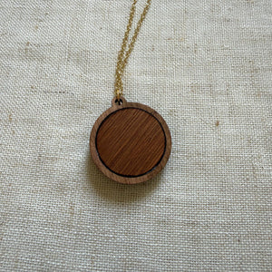 Wooden pendant necklace on a light fabric background