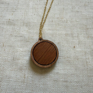 Wooden pendant necklace on a light fabric background