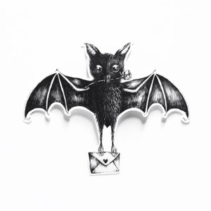 A black and white bat-shaped sticker holding a small envelope, shown against a plain white background.