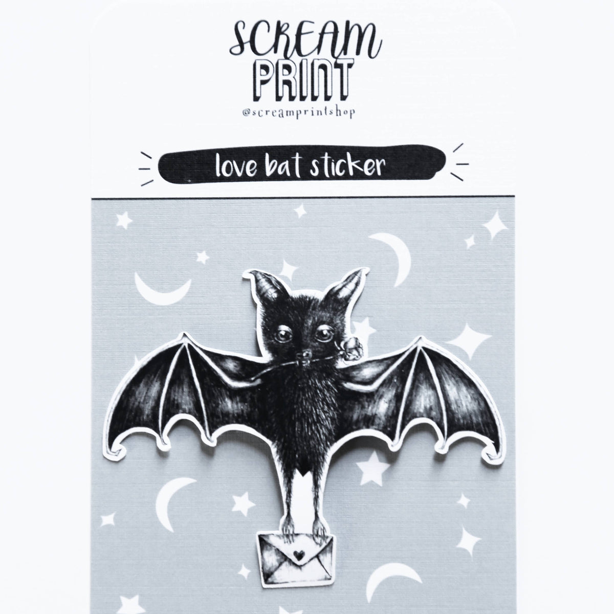 A black bat sticker with wings spread, holding a small silver envelope, mounted on a light gray backing card. The card has white stars and crescent moons and reads 'SCREAM PRINT' and 'love bat sticker'.