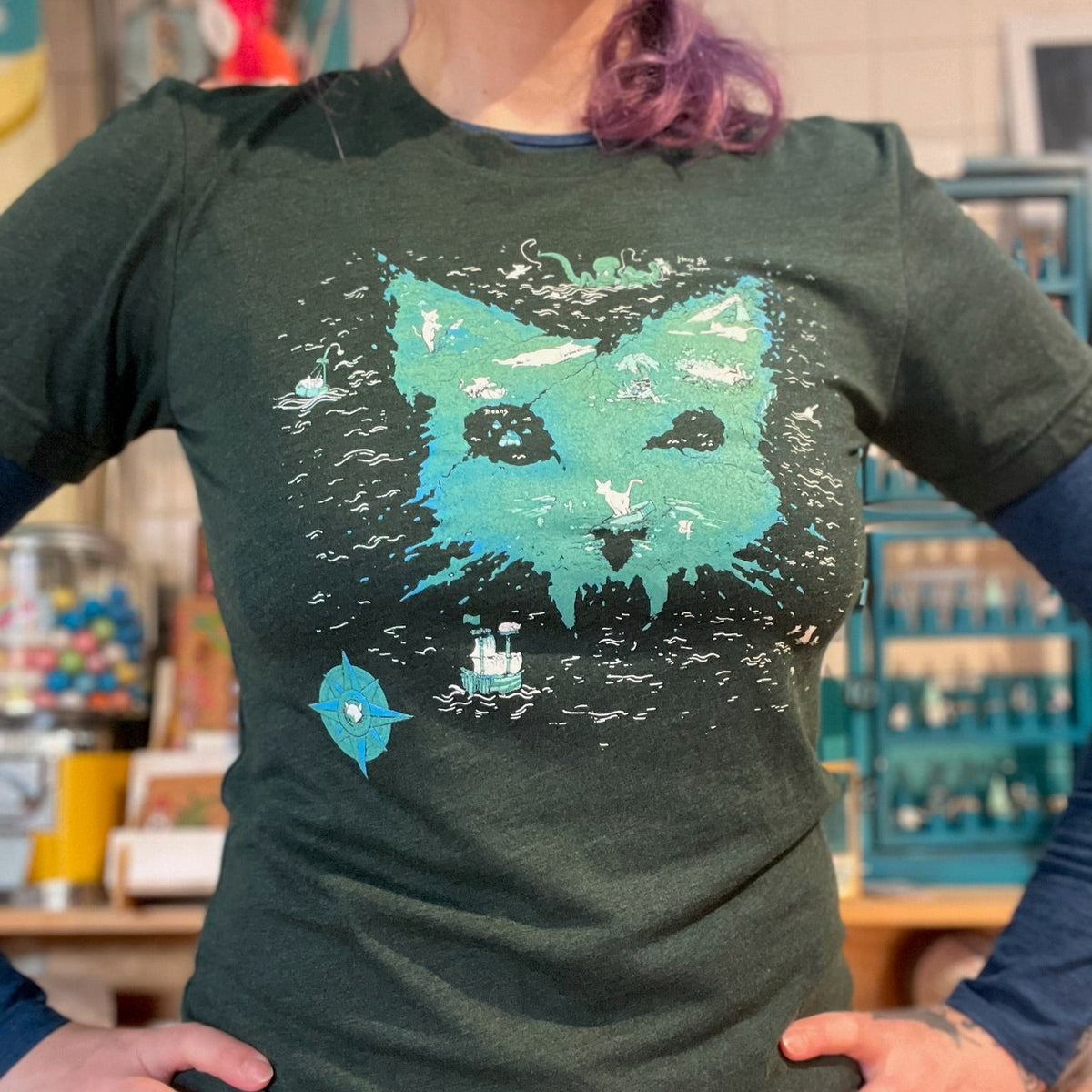 Person wearing a green catographer design tshirt in a store setting. 