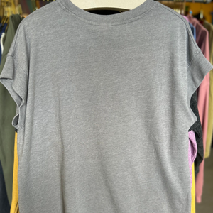 Gray t-shirt on a hanger with colorful shirts in the background