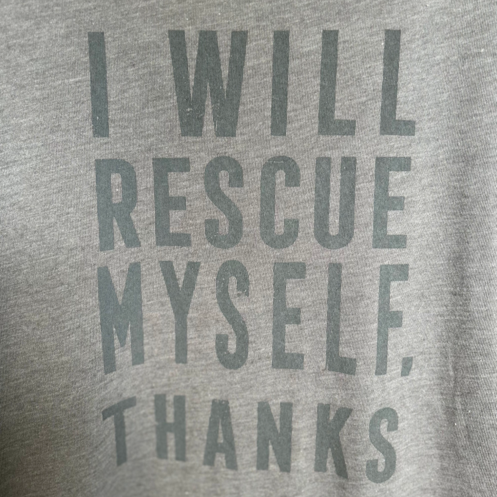 Gray t-shirt with text 'I WILL RESCUE MYSELF, THANKS' on a plain background