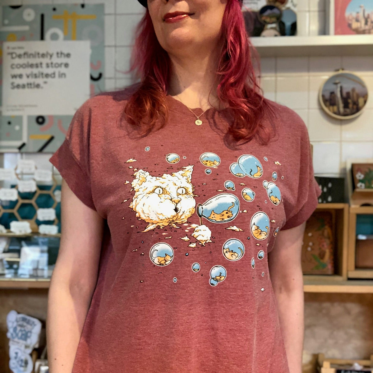 Person wearing a red t-shirt with a graphic design in a store setting