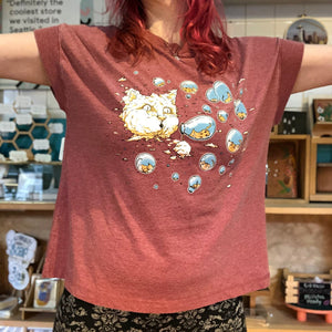 Person wearing a red t-shirt with a cartoon design in a store setting