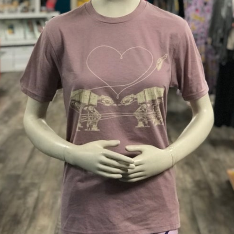 Mannequin wearing a mauve t-shirt with two at-ats falling in love in a store setting. 