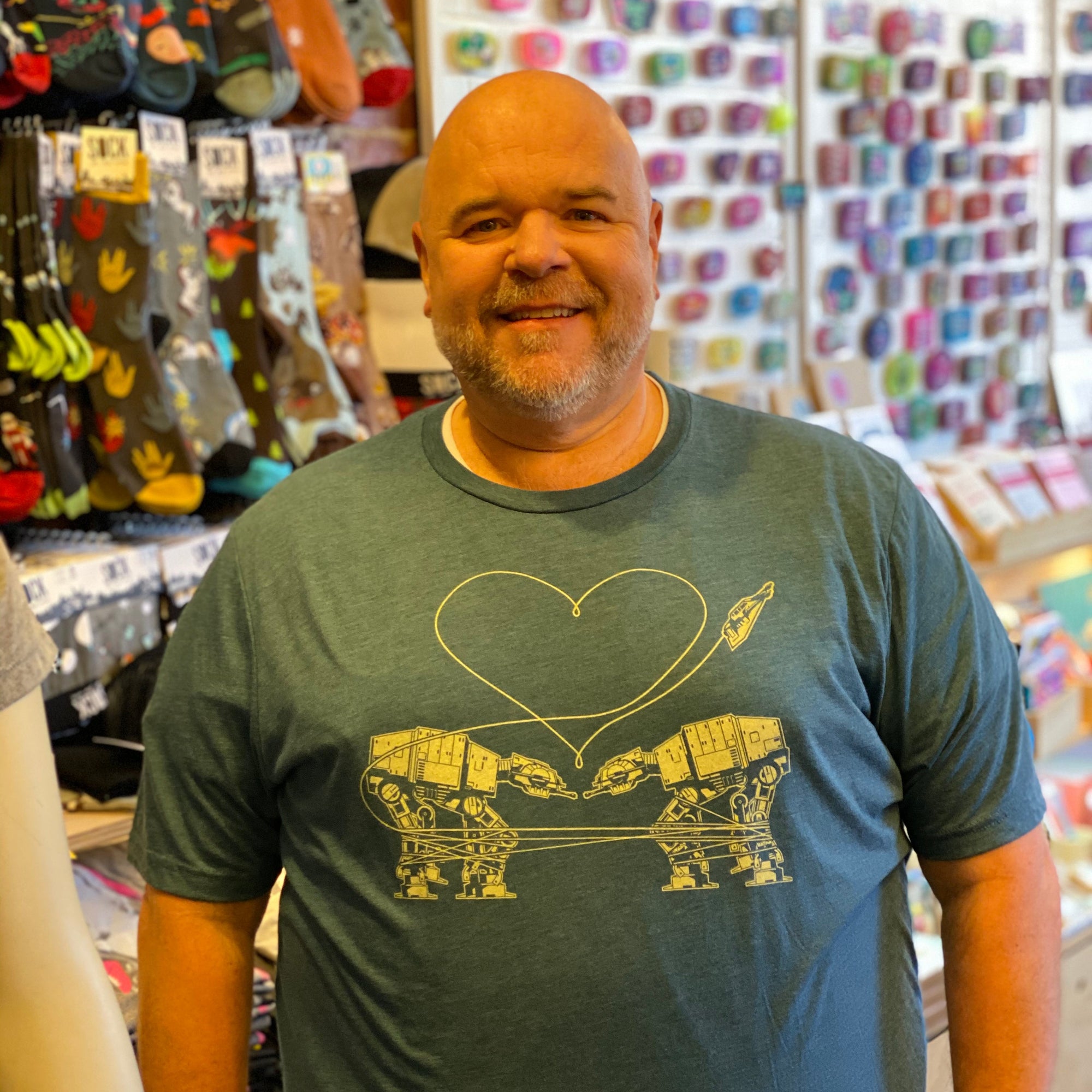 Man wearing a slate blue t-shirt with two at-ats falling in love. Awh!