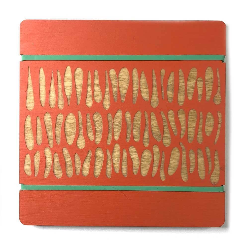 Orange wooden flower press with engraved leaf shapes and green rubber bands