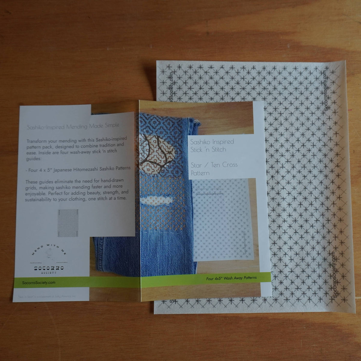 Packaging and instruction booklet for the star/ten cross stick and stitch pattern from Socorro Society against a wooden background. 