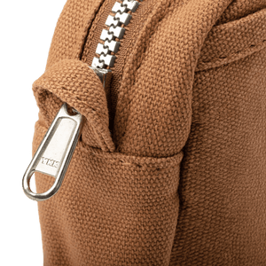 Close-up of a brown textured fabric with a metal zipper 