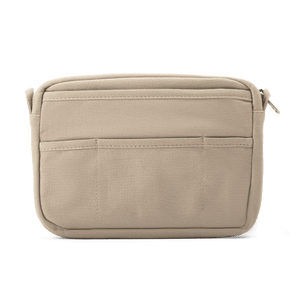 Beige travel pouch with multiple compartments on a white background