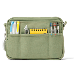 Green pouch with compartments holding stationery items on a white background