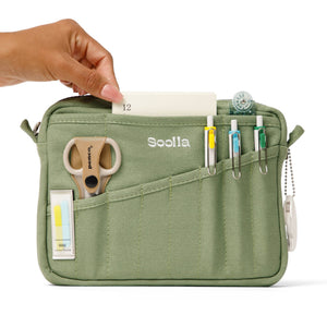 Green organizer bag with stationery items and a hand interacting with it, branded 'Soolla'.