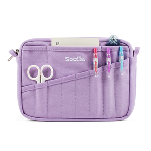 A lavender purple fabric pencil case with multiple pockets, shown on a white background with stationery items inserted. The brand name 'Soolla' is printed on the front.