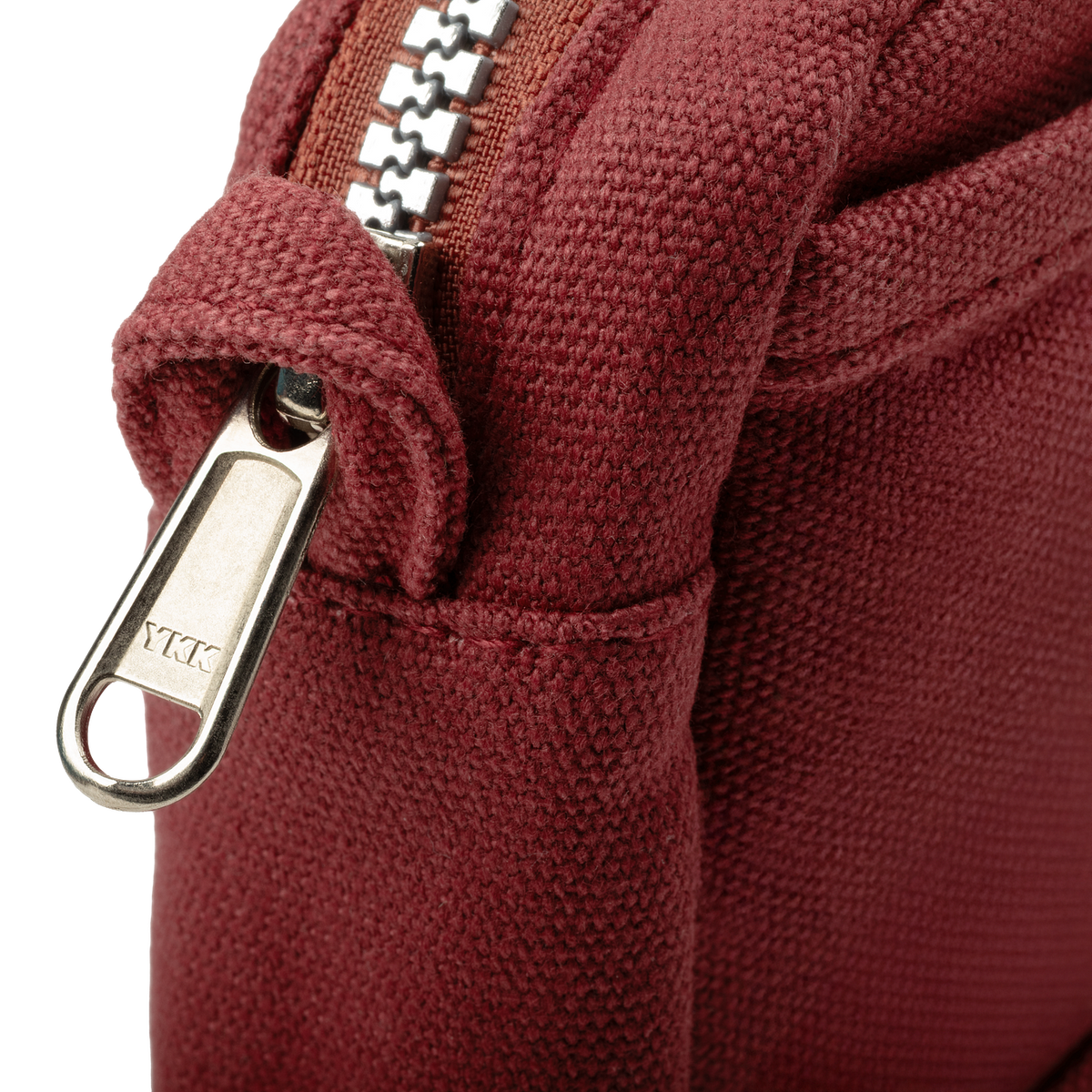 Close-up of a maroon pouch with a zipper and 'YKK' brand logo.