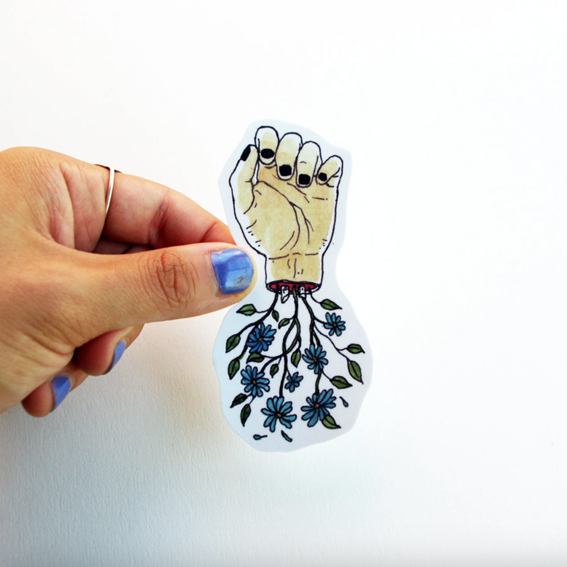 Hand holding a sticker with a hand and floral design on a white background