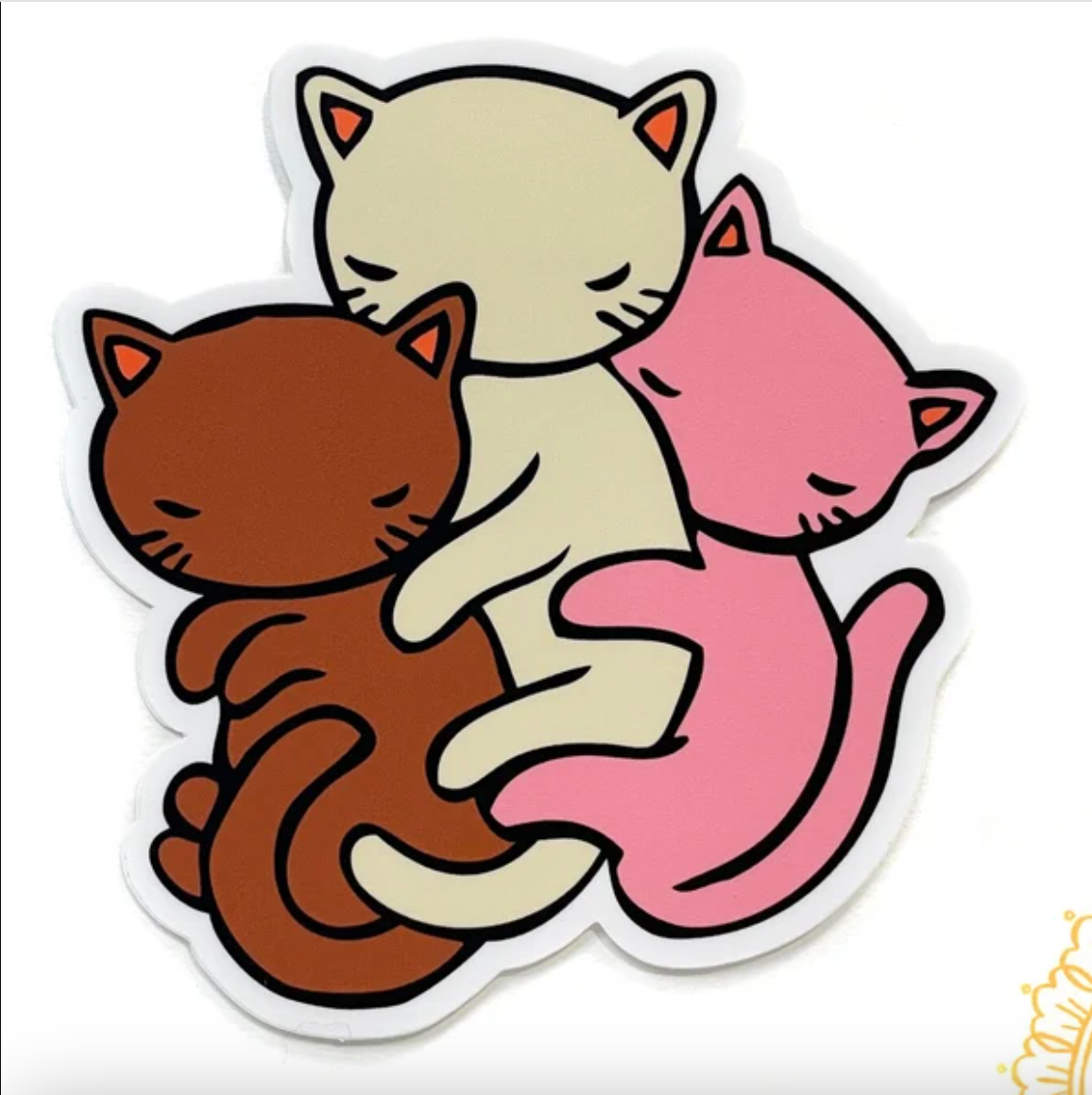 Three cats spooning in brown, white, and pink. 