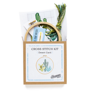 Cross stitch kit with embroidery hoop and materials on a white background