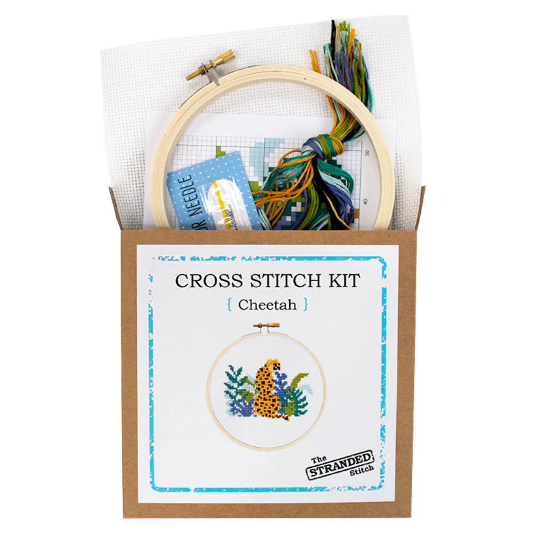 Cross stitch kit with hoop, thread, and pattern card on a white background. The front shows a cheetah surrounded by plants. 