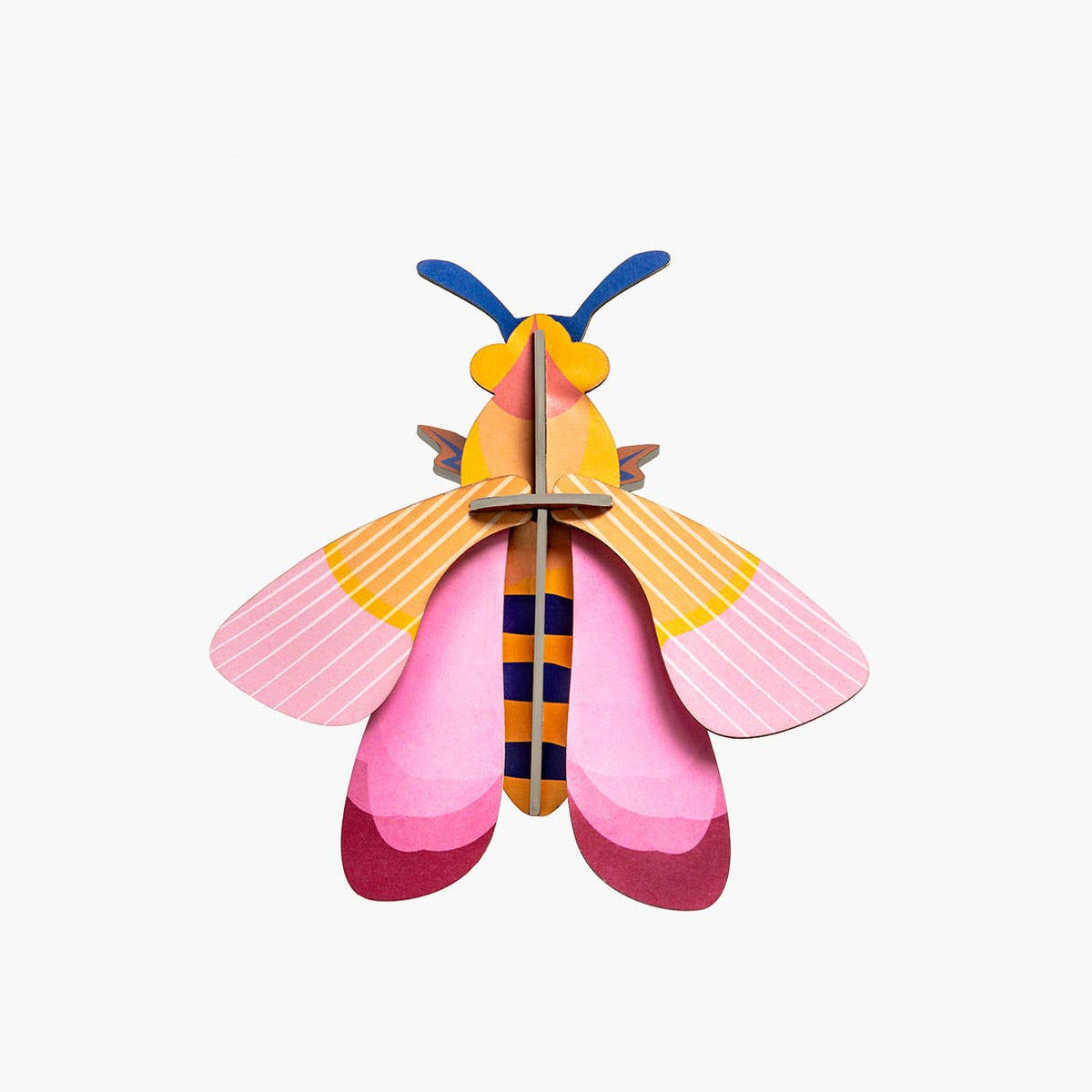 Cardboard sculpture of a bee with pink wings against a white background. 