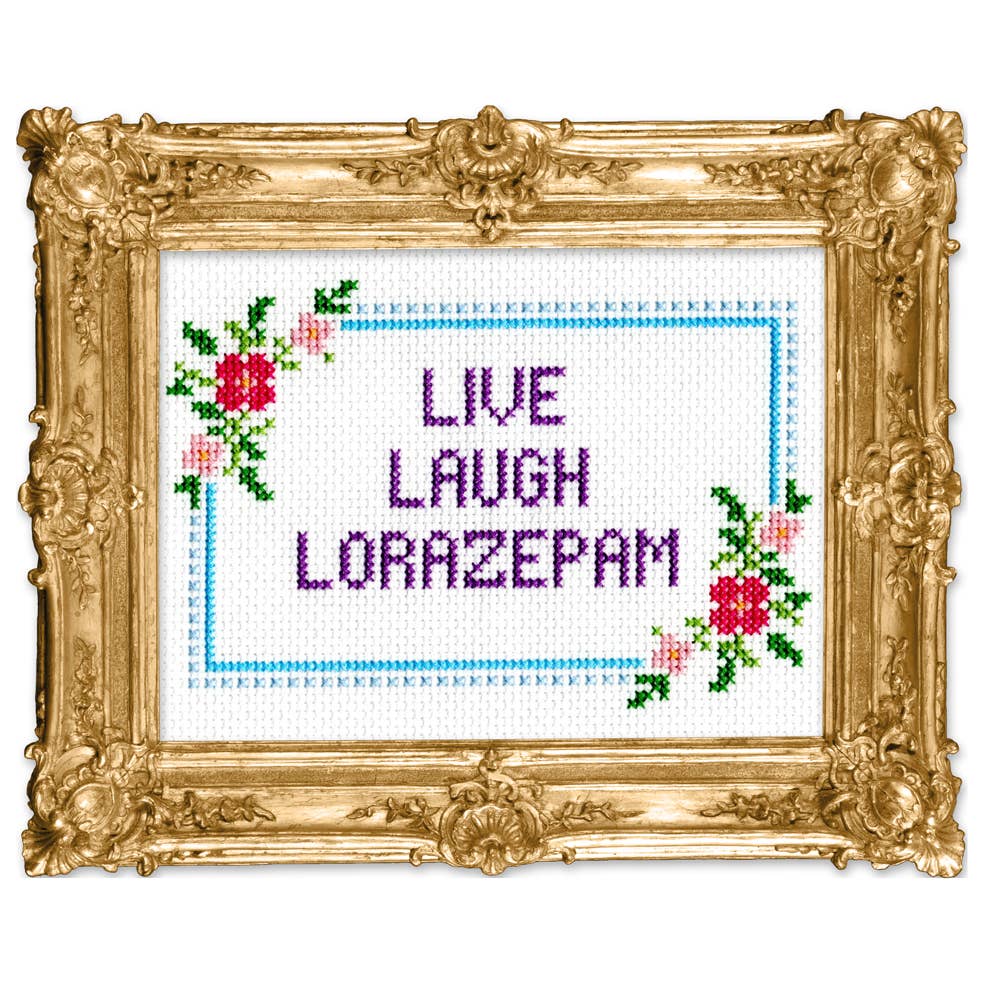 Cross stitch pattern in a gold frame that reads "LIVE LAUGH LORAZEPAM" with a floral border. 