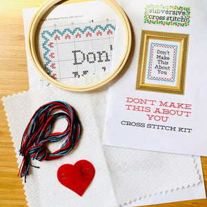 Cross stitch kit with hoop, thread, and printed pattern on a wooden surface